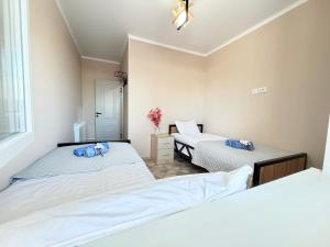 a bedroom with two beds and a window at Like House Karakol in Karakol