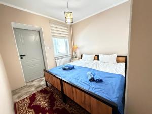 a bedroom with a bed with two pairs of shoes on it at Like House Karakol in Karakol +22 photos
