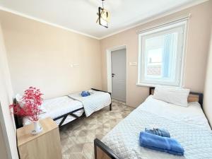 a bedroom with two beds and a window at Like House Karakol in Karakol