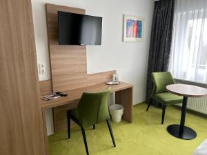 a room with a table and two chairs and a tv at EDELFUCHS Rote-Lache in Forbach