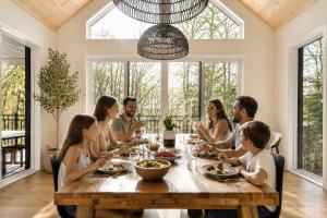 a group of people sitting around a wooden table at Spa & Babyfoot - Chalet BOREA in Saint-Faustin