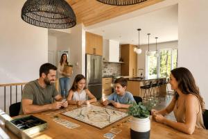 a group of people sitting around a table in a kitchen at Spa & Babyfoot - Chalet BOREA in Saint-Faustin
