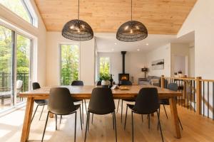 a dining room with a wooden table and chairs at Spa & Babyfoot - Chalet BOREA in Saint-Faustin +37 photos