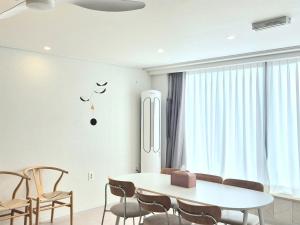 a dining room with a white table and chairs at 포포스테이 in Busan