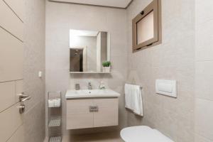 a white bathroom with a sink and a toilet at Ocean & Sunset View Pool & Parking in Tamraght Ouzdar +25 photos