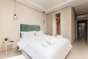 a bedroom with a large white bed with towels on it at Ocean & Sunset View Pool & Parking in Tamraght Ouzdar