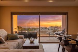 a living room with a couch and a large glass door at Ocean & Sunset View Pool & Parking in Tamraght Ouzdar