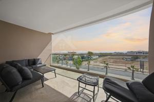 a living room with a large window with a view at Ocean & Sunset View Pool & Parking in Tamraght Ouzdar