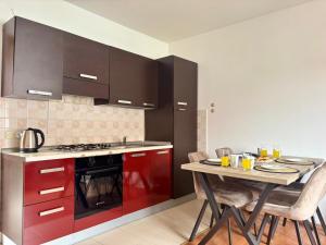 a kitchen with red cabinets and a table with chairs at Cozy apartment Ivana in Gornji Karin