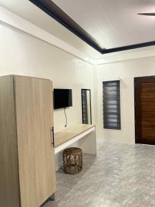 a living room with a tv and a stool at Reynaldos Place Corporation in Vigan