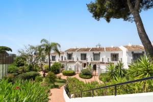 an exterior view of a white house with trees and plants at Las Pergolas in Marbella