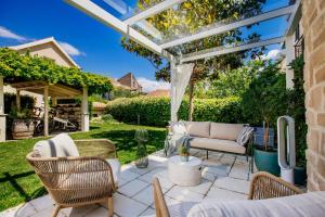 a patio with a couch and chairs under a pergola at Villa Pauletta in Split
