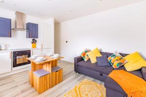 a living room with a couch and a kitchen at Modern City Centre Flat in Norwich