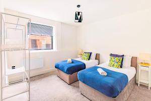 a bedroom with two beds and a glass shower at Modern City Centre Flat in Norwich +10 photos