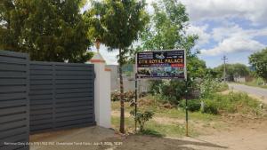 a sign for a golf course village next to a fence at GTR Royal Palace cottage in Wodapatti