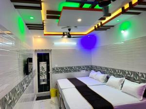 a bedroom with a bed in a room with green lights at GTR Royal Palace cottage in Wodapatti