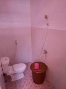 a small bathroom with a toilet and a shower at Bunaken GuestHouse in Bunaken