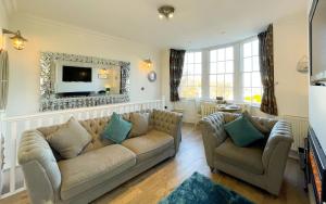 a living room with a couch and a tv at Spinnaker, Whitehall in Ardeonaig