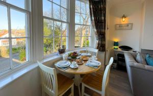 a dining room with a table and chairs and windows at Spinnaker, Whitehall in Ardeonaig