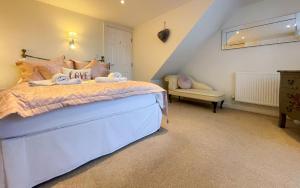 a bedroom with a large bed and a chair at Spinnaker, Whitehall in Ardeonaig