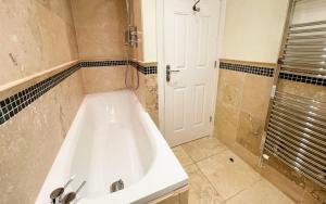 a bathroom with a white tub and a shower at Spinnaker, Whitehall in Ardeonaig +15 photos