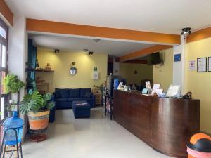 a lobby with a bar and a blue couch at Hotel Casa Rus in Comitán
