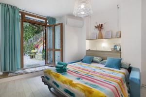 a bedroom with a bed and a large window at Quercia -in Caruggiu di Via Vecchia in Orco Feglino