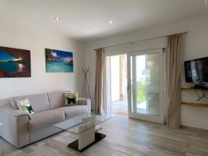 a living room with a couch and a sliding glass door at R House II - Puntocasabudoni in Budoni