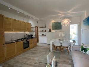 a kitchen and living room with a table and a couch at R House II - Puntocasabudoni in Budoni