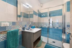 a blue and white bathroom with a sink and a shower at Quercia -in Caruggiu di Via Vecchia in Orco Feglino