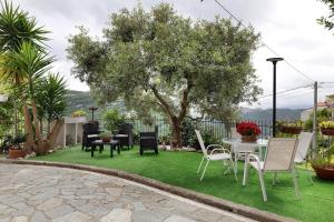 a yard with chairs and a table and a tree at Quercia -in Caruggiu di Via Vecchia in Orco Feglino