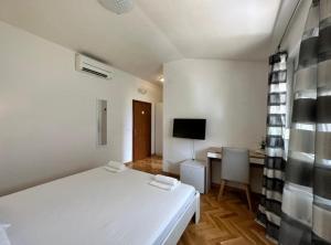 a bedroom with a white bed and a desk at Villa Dante with swimming pool in Trogir