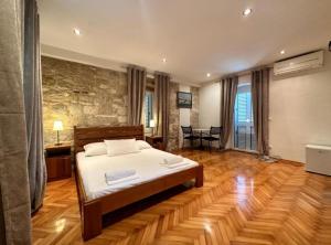 a bedroom with a bed and a stone wall at Villa Dante with swimming pool in Trogir +125 photos