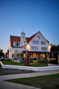 a large white building with a statue in front of it at Lebeaubylivingroom Hotel in Knokke-Heist