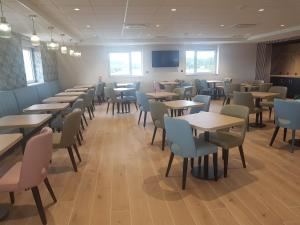 a dining room with tables and chairs at The Originals City Hôtel-Restaurant-Terrasse du PAarc Gravelines Dunkerque in Gravelines