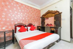 a bedroom with a large bed with red pillows at Hotel Pleasure Palace in Indore