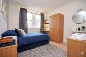 a bedroom with a blue bed and a mirror at Ocean Quay in Greenock