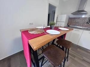 a kitchen with a wooden table with a pink blanket on it at Apartamento Empul Barrosa Beach in Novo Sancti Petri +5 photos
