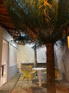a table and chairs and a palm tree in a room at RODRIGUES CASA de TEMPORADA em Barreirinhas in Barreirinhas