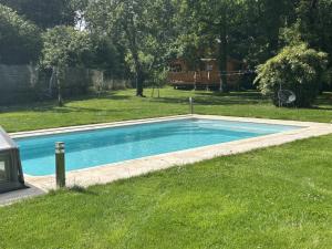 a swimming pool in the grass in a yard at Les Jardins de Valinor in Thénezay