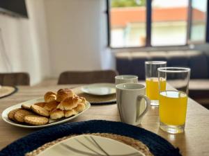 a table with a plate of bread and glasses of orange juice at Cozy apartment Ivana in Gornji Karin