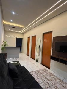 a living room with a couch and a flat screen tv at RODRIGUES CASA de TEMPORADA em Barreirinhas in Barreirinhas