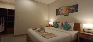 a hotel room with two beds and two pictures on the wall at Kubunaku Sanur Bali in Sanur +80 photos
