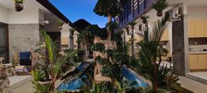 an apartment building with a swimming pool and plants at Kubunaku Sanur Bali in Sanur
