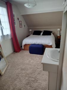 a bedroom with a bed and a sink in it at maison fleurie in Longué