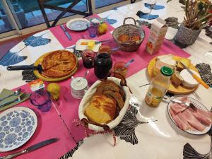 a table with a bunch of food on it at maison fleurie in Longué +2 photos
