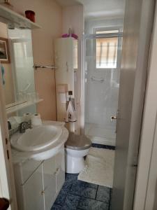 a white bathroom with a toilet and a sink at maison fleurie in Longué