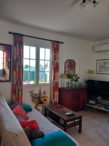 a living room with a couch and a tv at Villa Cardicciosa in Ghisonaccia