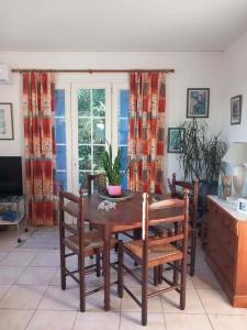 a dining room with a wooden table and chairs at Villa Cardicciosa in Ghisonaccia