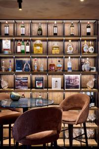 a room with a table and chairs and shelves with bottles at Lebeaubylivingroom Hotel in Knokke-Heist